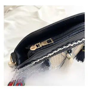 Detail of smooth gold metal zipper and ethnic geometric woven texture on a blue bucket bag