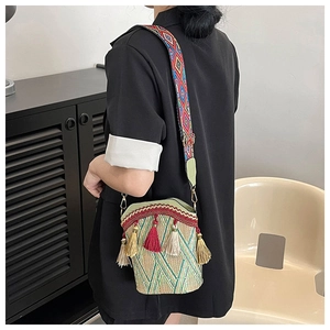 Detail of woven bucket bag with colorful tassels and ethnic geometric wide shoulder strap
