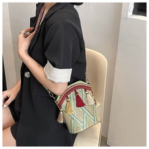 Detailed close-up of ethnic bucket bag with colorful tassels and woven texture