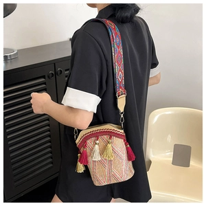 Detail of bohemian bucket bag with colorful geometric patterns and decorative tassels