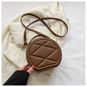 Close-up of a brown quilted round crossbody bag with retro geometric diamond stitching