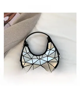 Dettaglio del motivo geometrico a triangoli argentati sulla borsa a spalla a mezzaluna