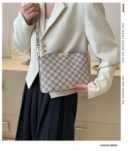 Detail view of brown pattern crossbody bag with premium gold zipper and leather texture