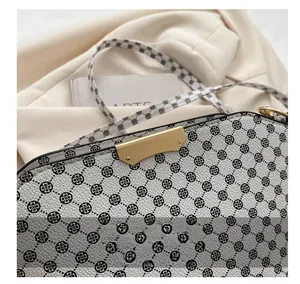 Detailed macro view of a floral crossbody bag with gold hardware and leather texture