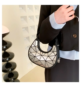 Dettaglio della borsa geometrica argento a mezzaluna indossata come borsa a spalla