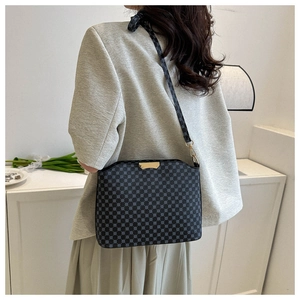 Detail shot of a vintage pattern crossbody bag shown on model in a minimalist setting