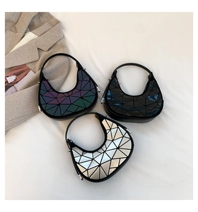 Dettaglio di borse hobo geometriche in viola, nero e argento con finiture metallizzate