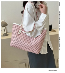 Pink geometric tote bag with white straps shown on model for size perspective