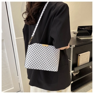 Detail view of large capacity crossbody bag with vintage geometric pattern and gold buckle