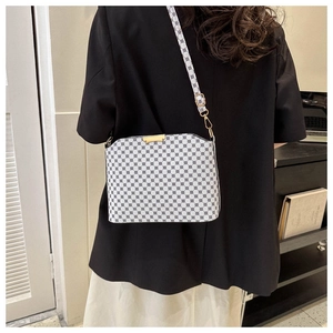 Model back view showing the white patterned crossbody bag with gold metal buckle