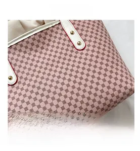 Detail of pink tote bag showing geometric clover pattern and red-edged white handle