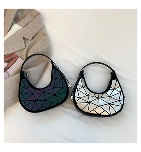 Dettaglio del motivo geometrico a triangoli sulle borse a mezzaluna argento e iridescenti
