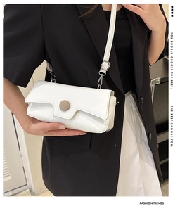 Close-up of a white rectangular crossbody bag with a large round button accent