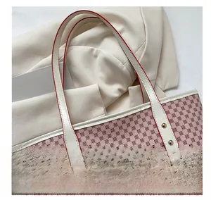 Pink tote bag detail with geometric logo pattern, white handle, and red edge finishing