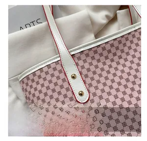 Close-up of pink tote bag with clover pattern and white strap featuring gold rivets