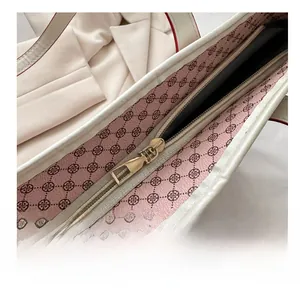 Detailed macro view of the gold metal zipper and pink clover patterned lining of the tote bag