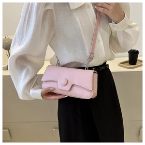 Pale pink rectangular crossbody bag shown on waist with adjustable leather strap