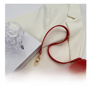 Detail showing the red quilted leather shoulder strap and glossy gold metal chain