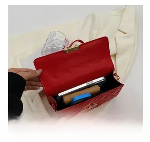 Interior view of red quilted crossbody bag showing storage capacity for phone and wallet
