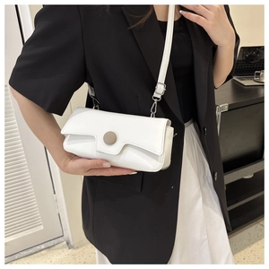 Detail of the white rectangular crossbody bag with unique geometric flap and round buckle