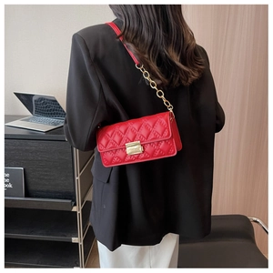 Fashionable red quilted shoulder bag with gold chain strap on professional model back