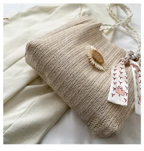 Vue détaillée du sac en paille avec texture tissée et motif marguerite décoratif