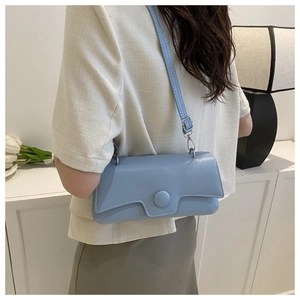 Light blue matte leather rectangular crossbody bag shown on model in minimalist setting