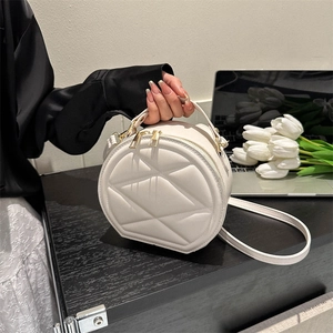 Elegant cream quilted round crossbody bag with gold hardware and top handle for women