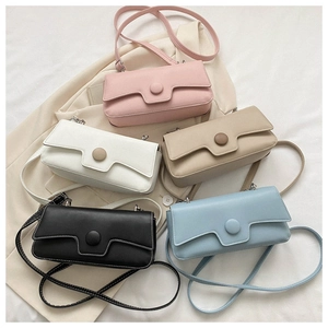 Flat lay of small crossbody bags in five colors with round buckles and matte leather texture