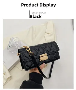 Detail of black quilted leather shoulder bag with gold metal clasp and chunky chain