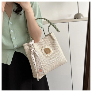 Détail du sac cabas en paille avec marguerite 3D et foulard fleuri sur les anses