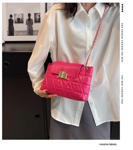 Detail of pink quilted crossbody bag featuring a gold twist lock and chain strap