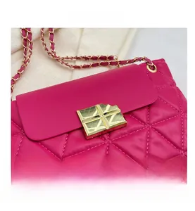 Close-up of fuchsia quilted bag with glossy texture and gold metallic hardware lock