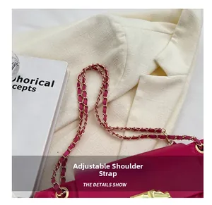 Detail of adjustable chain strap and gold clasp on rose red quilted crossbody bag