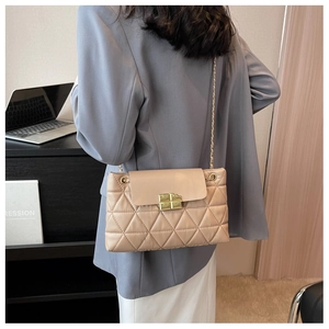 Close-up of beige quilted chain bag featuring a gold square lock and leather finish