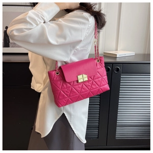 Close-up of quilted pattern and gold metal chain strap on rose pink crossbody bag