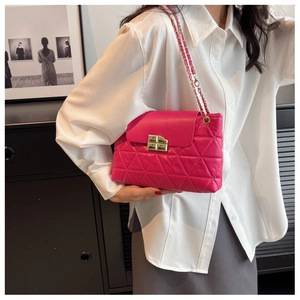 Detailed view of rose pink quilted chain bag with gold buckle on model outfit