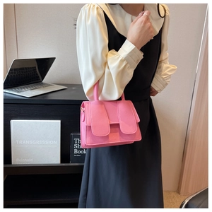 Detail van roze mini-tas van litchi-leer met gouden gesp en bovenste handgreep