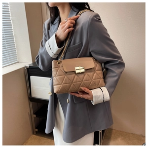 Quilted shoulder bag with gold chain strap and cross lock shown on model