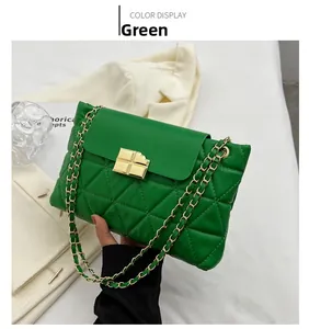 Detail of green quilted chain bag with gold twist lock and fine diamond texture