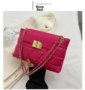 Detail of rose red quilted crossbody bag with unique gold bite-shaped metal buckle and chain