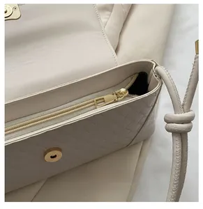 Detail of premium beige woven leather handbag with gold zipper and intricate texture