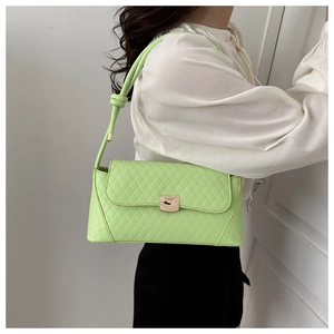 Close-up of light green quilted shoulder bag with golden clasp and knot strap detail