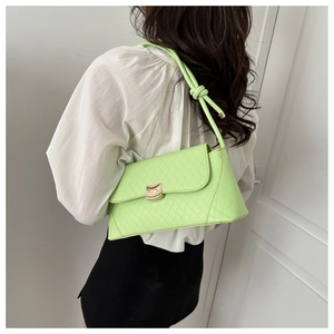 Close-up of neon green quilted handbag showing golden lock and leather knot shoulder strap
