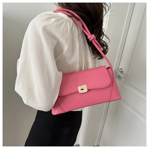 Detail of pink quilted shoulder bag featuring gold buckle and knotted strap detail