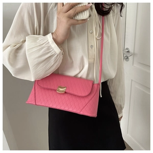 Detail of rose pink quilted crossbody bag with gold metallic buckle and sleek strap