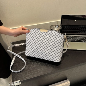 Chic monochrome polka dot crossbody bag with gold hardware and adjustable shoulder strap