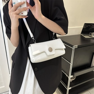Minimalist white leather crossbody bag for women styled with black blazer and dress