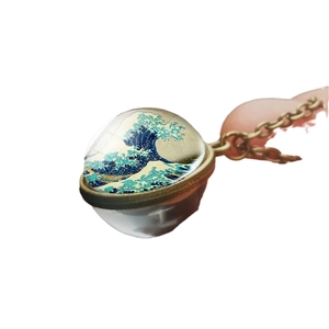 Vintage Bronze-Halskette mit Great Wave Kunst unter Glaskuppel auf weißem Hintergrund