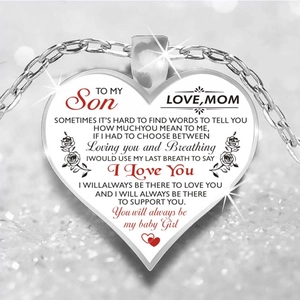 Macro shot of silver heart pendant for son with emotional engraving on glitter background